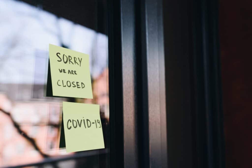 A door with notes that read "Sorry we are closed. Covid-19."